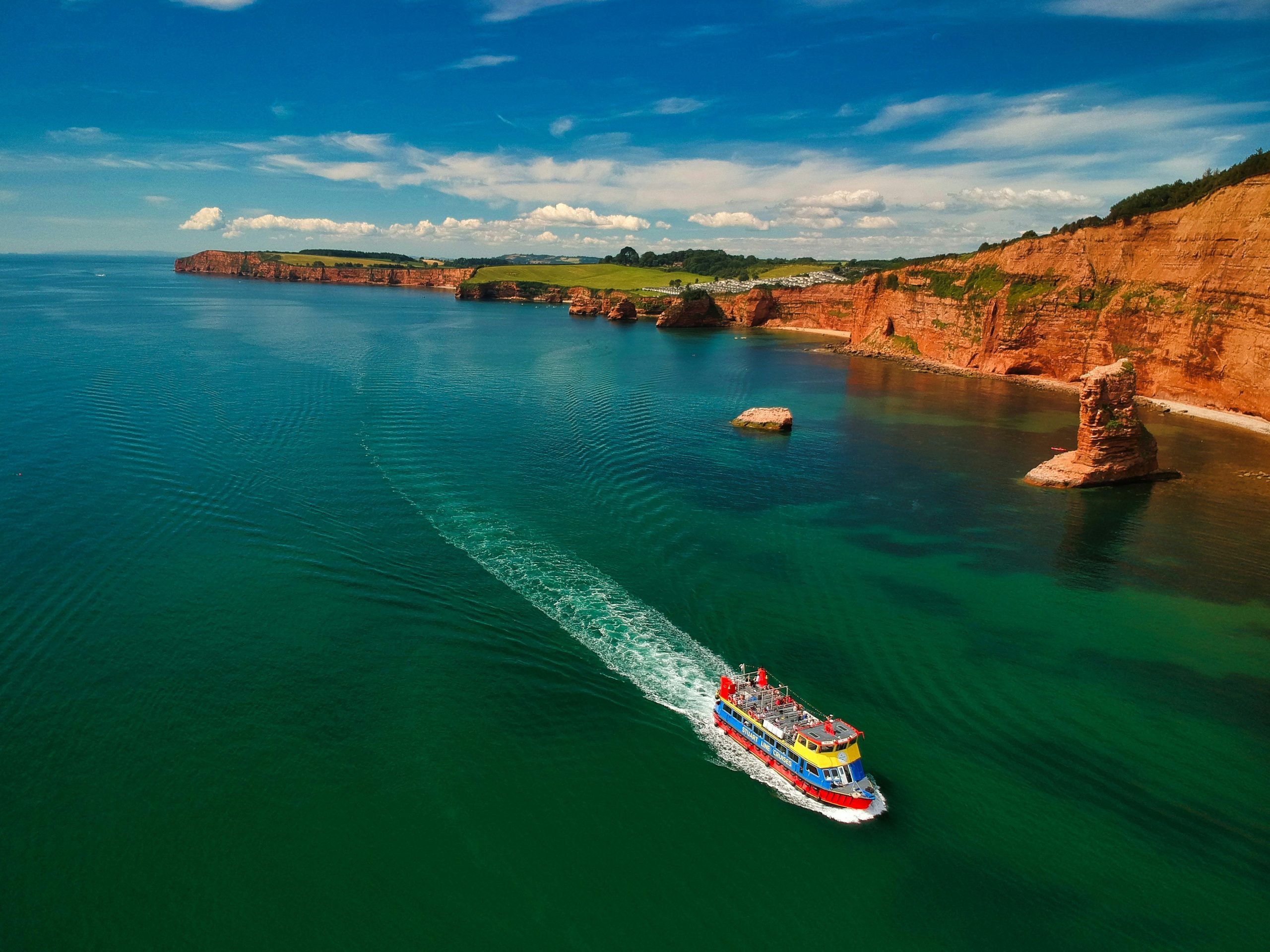 Cruisin' On A Sunny Afternoon - A sightseeing cruiser traces through clear Summer shallows off the Jurassic Coast, Devon, UK High Peak, Otterton, Sidmouth, UK